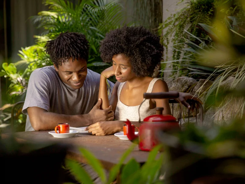 A donor couple smiles while reading an impact report letter from Faith in God Charity Missions.