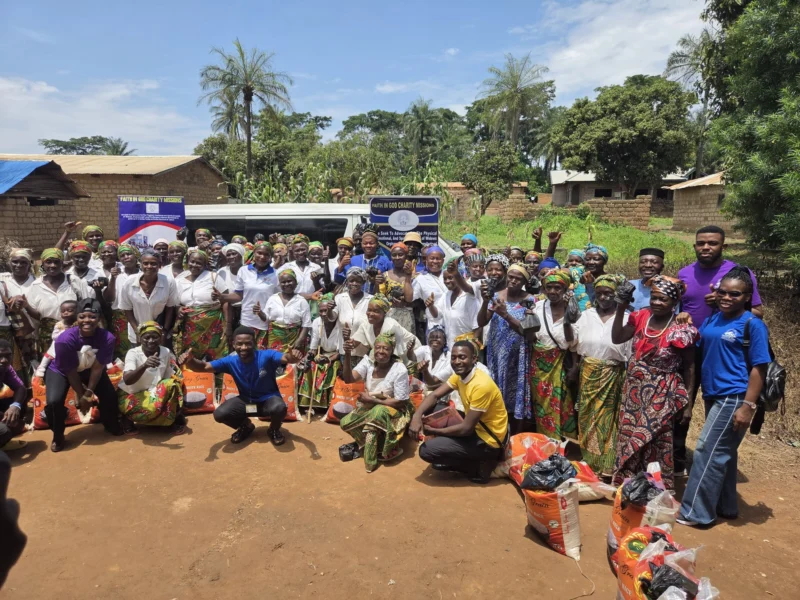 Community members gathered outdoors with supplies at an FIGCM livelihood distribution.