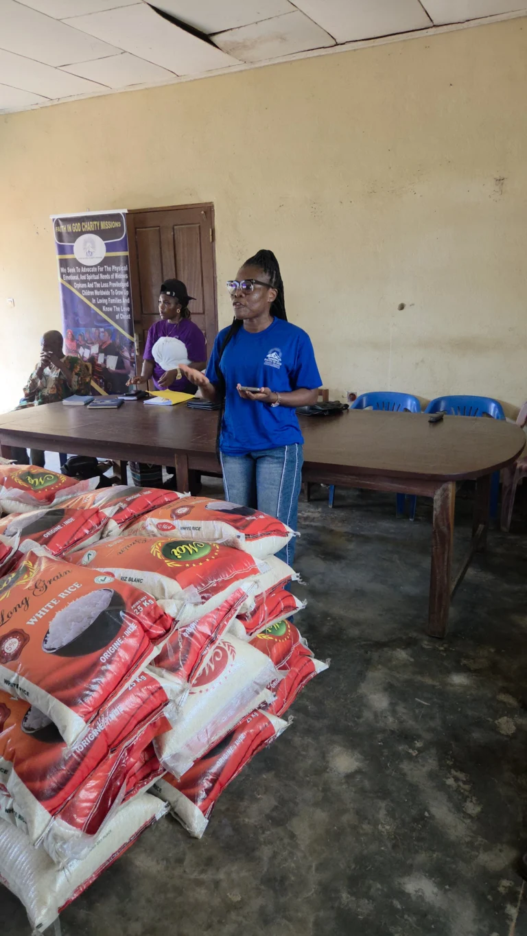 An FIGCM volunteer beside bags of rice prepared for distribution.