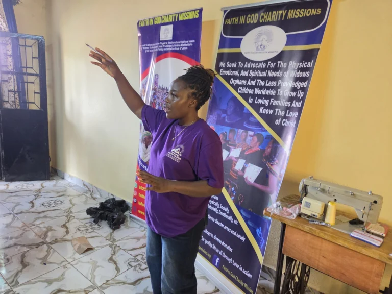 FIGCM volunteers in branded shirts talking together at a community event.